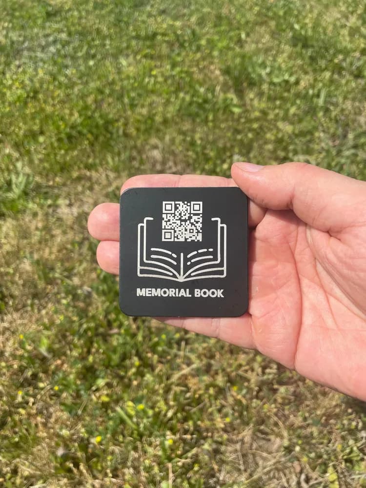 Pamiętnik Memorial Book - trwały nośnik z kodem QR trzymany w dłoni